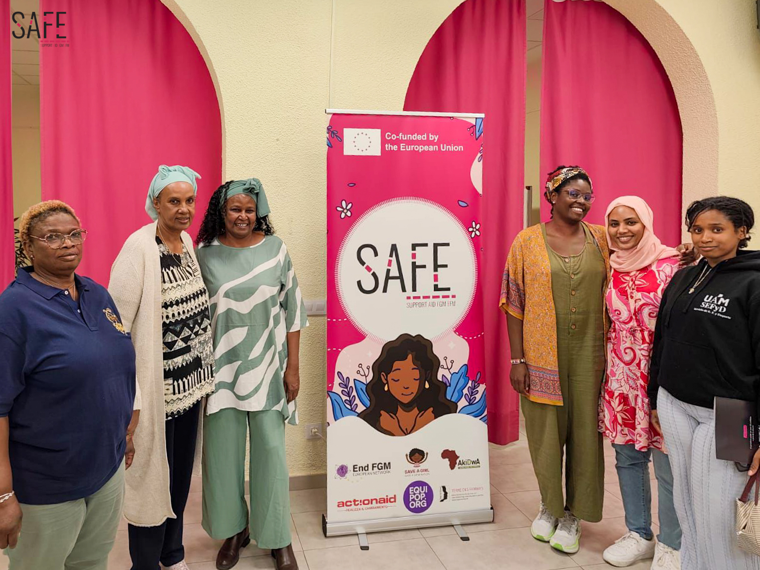 comunity experte and leader safe Fotografía que muestra un momento de encuentro entre un grupo de personas entorno a un rollup del proyecto SAFE